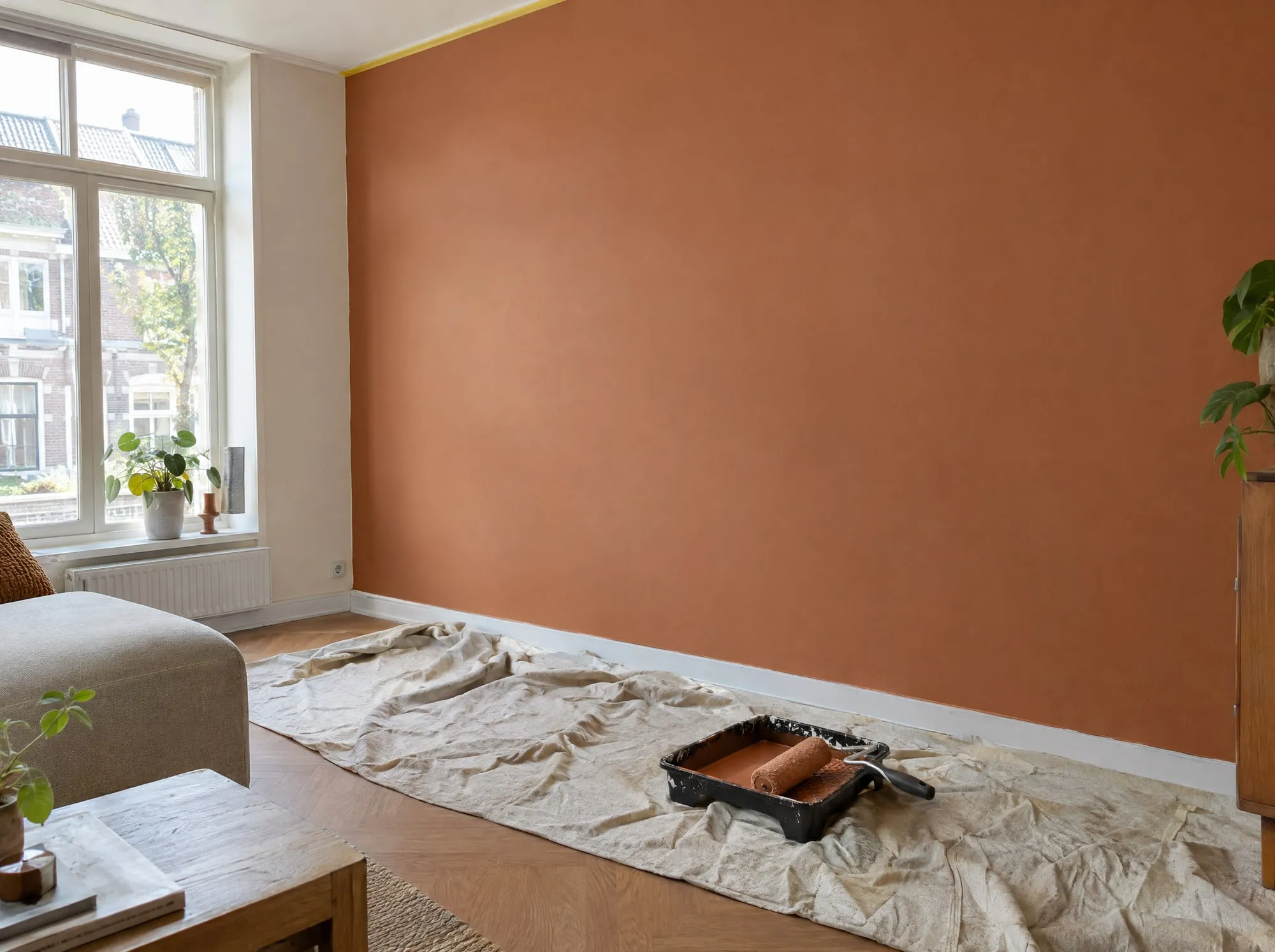 Woonkamer met een vers geschilderde muur in een warme kleitint