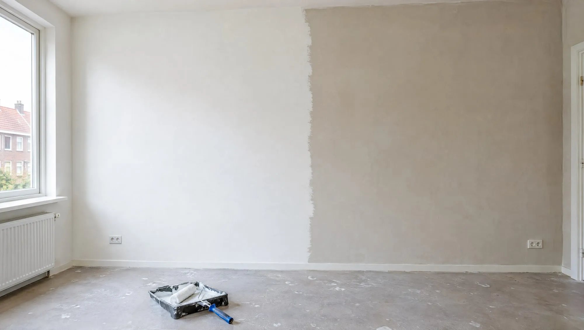 Gestucte muur die voor de helft al is geschilderd