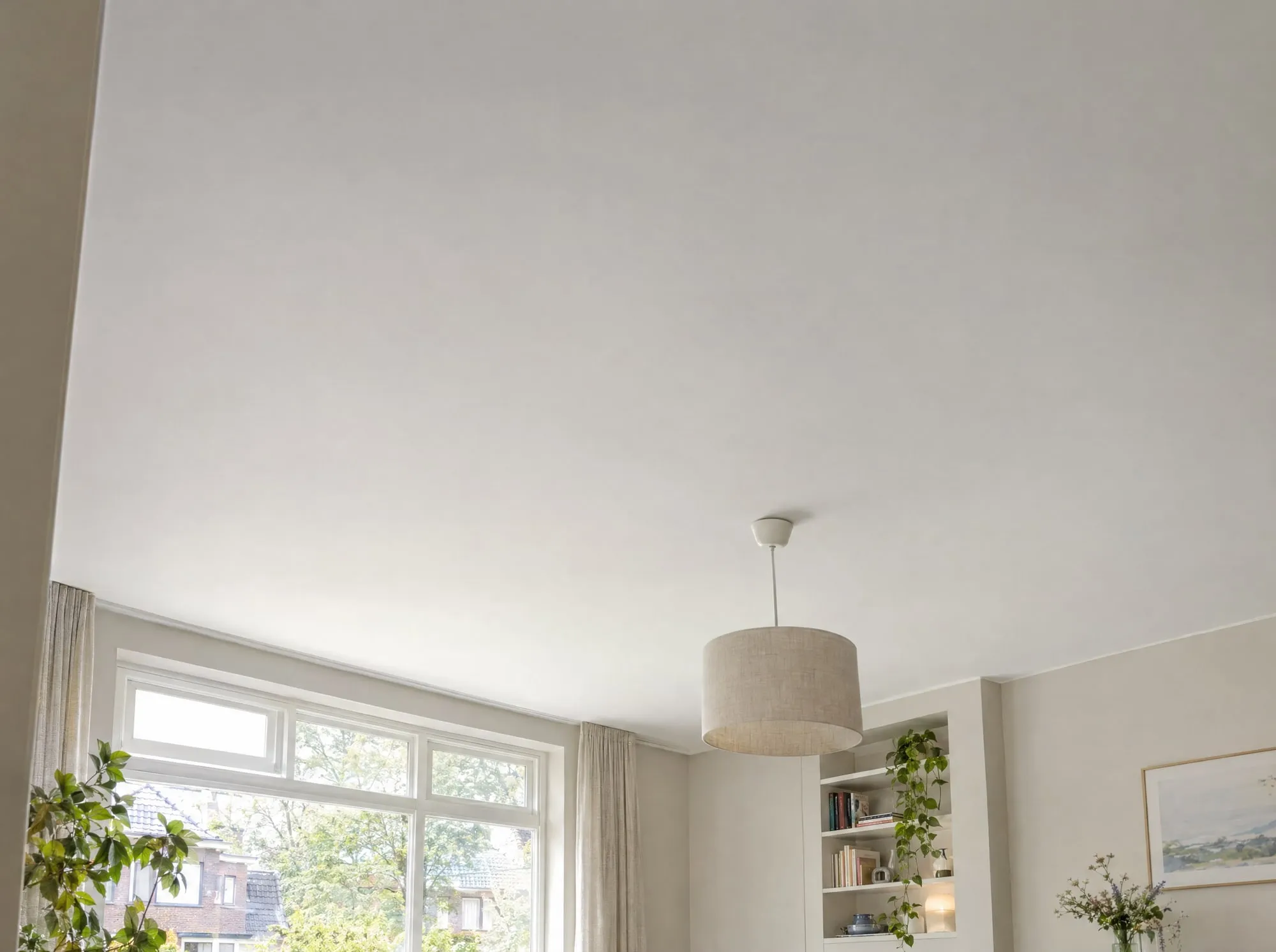Glad gestuct wit plafond in een woonkamer met een hanglamp